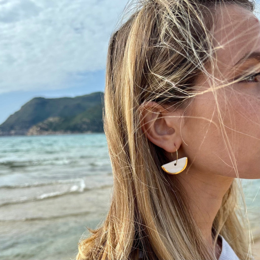 Doraluna | Handcrafted white ceramic dangle earrings with gold luster - Glow